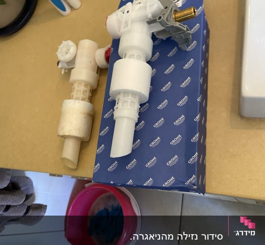 חלקי אינסטלציה על קופסת גרואה במטבח